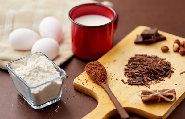 Chocolate, cocoa powder, milk, eggs and flour — Stock Photo, Image