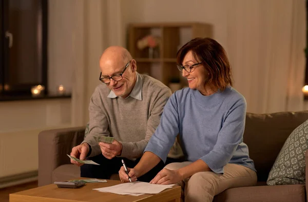 Senior couple with bills counting money at home — Stock Photo, Image