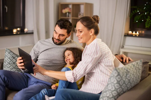 Famiglia felice con tablet computer a casa di notte — Foto Stock