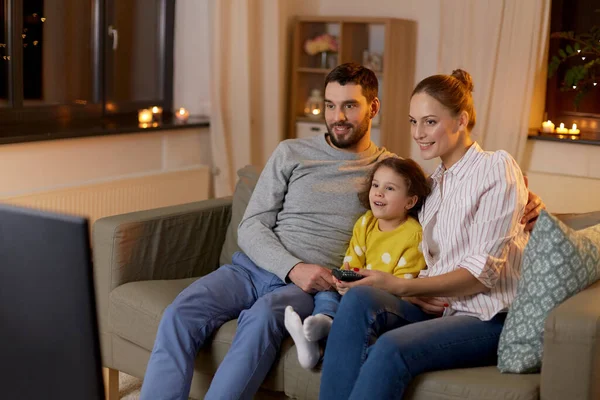 Familia feliz viendo la televisión en casa por la noche —  Fotos de Stock