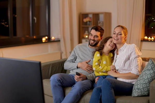 Familia feliz viendo la televisión en casa por la noche —  Fotos de Stock