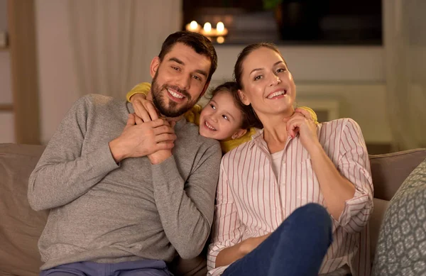 Retrato de la familia feliz sentado en el sofá en casa —  Fotos de Stock