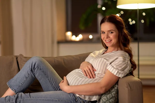 Feliz sorrindo mulher grávida no sofá em casa — Fotografia de Stock