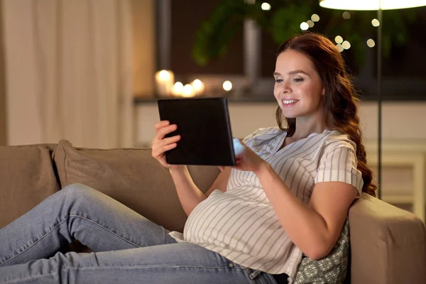 Szczęśliwa kobieta w ciąży z tabletem w domu — Zdjęcie stockowe