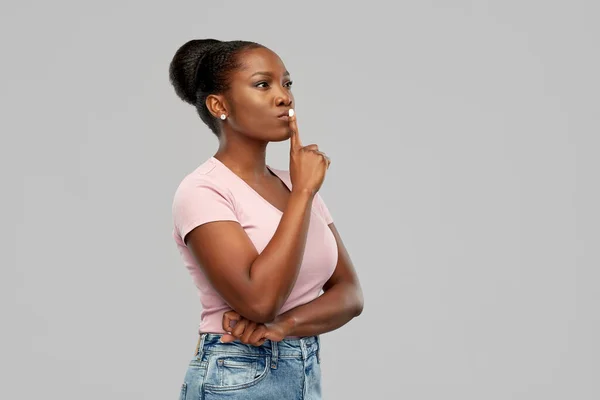 Afrikansk amerikansk kvinna med fingret på läpparna — Stockfoto