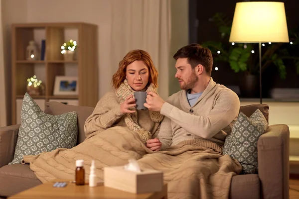 Enfermo joven pareja bebiendo té caliente en casa —  Fotos de Stock