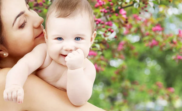 Madre con bebé sobre fondo de jardín de primavera —  Fotos de Stock