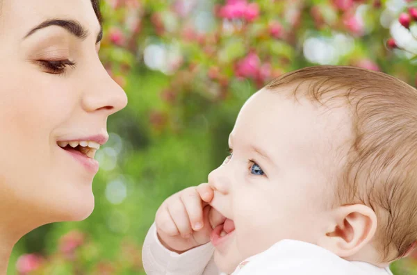 Mamma med barn över våren trädgård bakgrund — Stockfoto