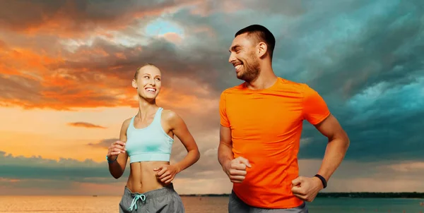 Smiling couple running over sea — Stockfoto