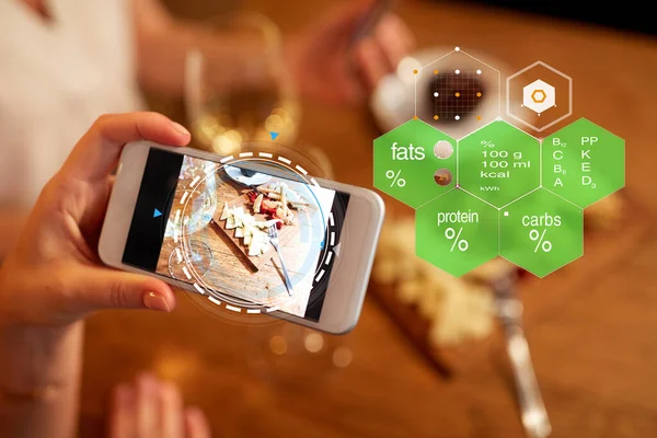 Ręce z jedzeniem na ekranie smartfona w restauracji — Zdjęcie stockowe