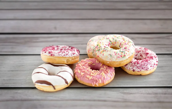 Close up van geglazuurde donuts op houten planken — Stockfoto