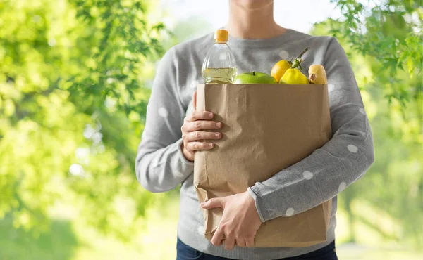 Close up of woman with paper bag full of food — Stock Photo, Image