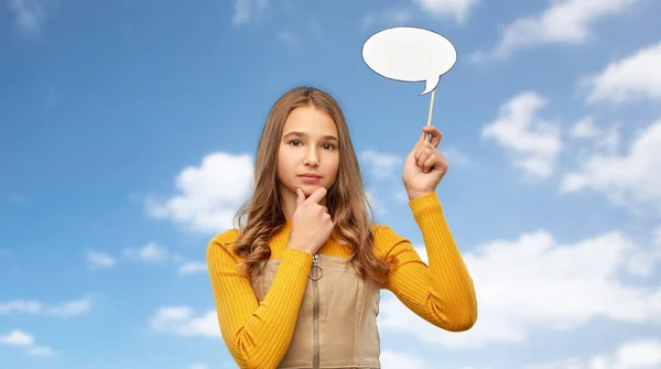 Teenage girl holding speech bubble over sky — Stockfoto