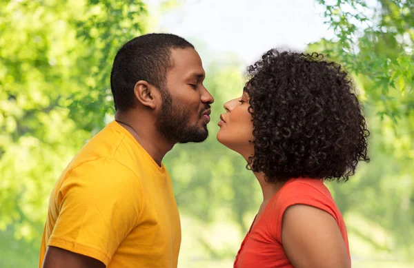 happy african american couple reaching for kiss