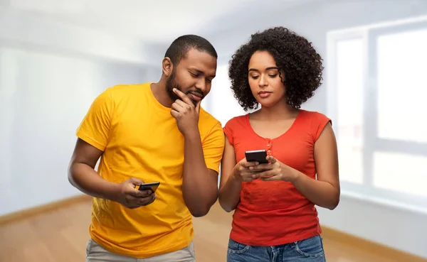 Happy african american couple with smartphones — Stock Photo, Image