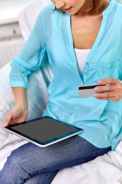 Mujer feliz con tablet PC y tarjeta de crédito en casa —  Fotos de Stock