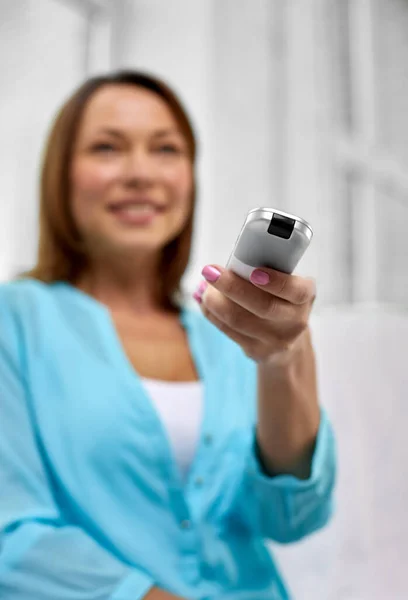 Close up of woman with tv remote control at home — ストック写真