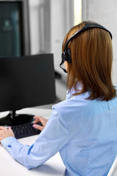 Zakenvrouw met headset en computer op kantoor — Stockfoto