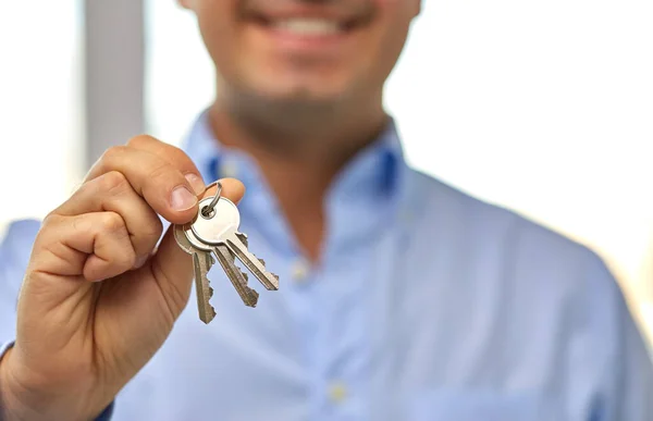 Close up de homem sorridente segurando as chaves da casa — Fotografia de Stock