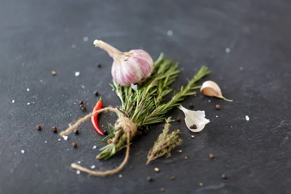 Rosemary, garlic and chili pepper on stone surface — Stock Photo, Image