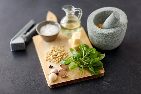 Ingredientes para molho de pesto de manjericão na placa de madeira — Fotografia de Stock