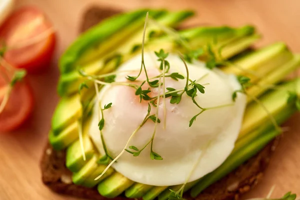 Toast bread with avocado, pouched egg and greens — 图库照片