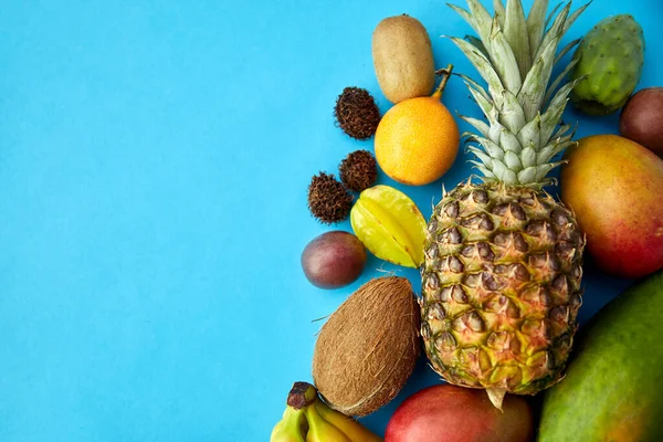 Muchas frutas exóticas diferentes sobre fondo azul — Foto de Stock