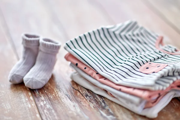 Close up of baby clothes on wooden table — Stockfoto