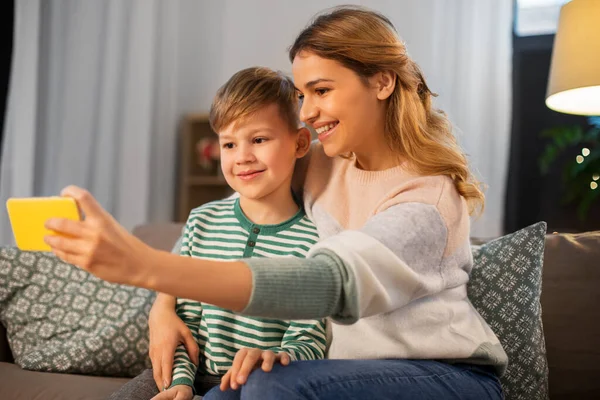 Madre e hijo tomando selfie por teléfono inteligente en casa —  Fotos de Stock