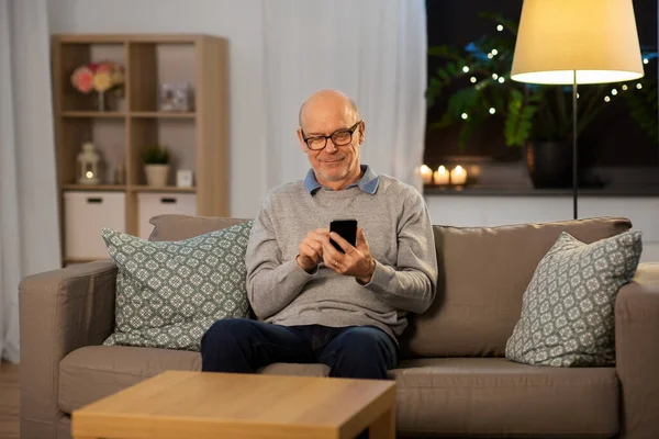 Heureux homme âgé textos sur smartphone à la maison — Photo