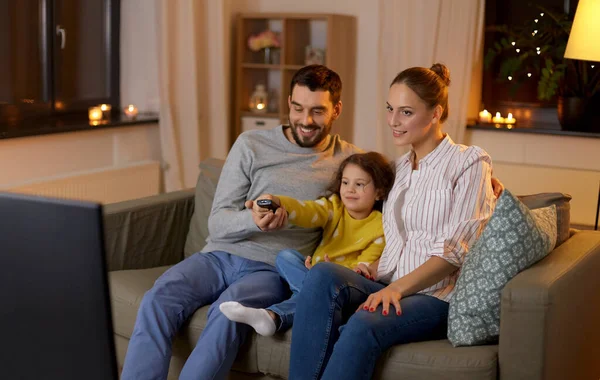 Familia feliz viendo la televisión en casa por la noche —  Fotos de Stock