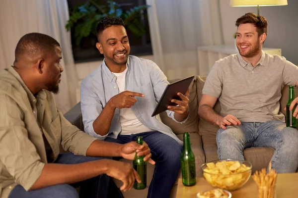 Amigos do sexo masculino com tablet pc beber cerveja em casa — Fotografia de Stock