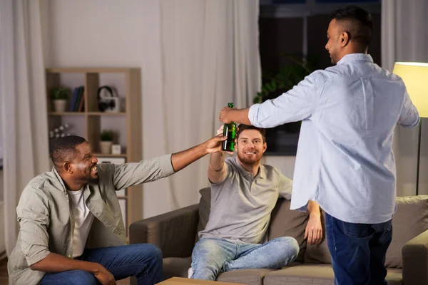 Felizes amigos do sexo masculino beber cerveja em casa à noite — Fotografia de Stock
