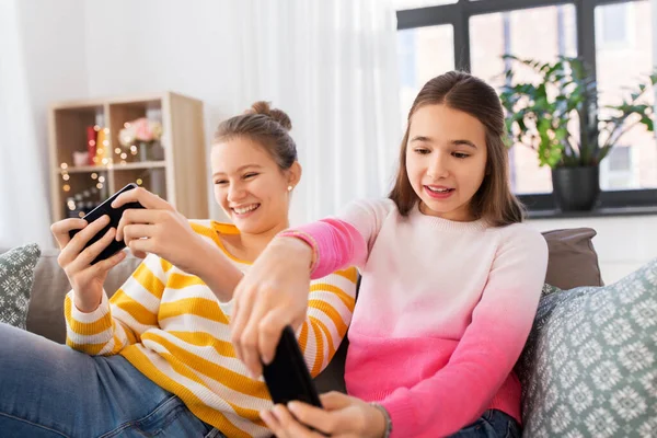 Girls and playing game on smartphones at home — Stock Fotó