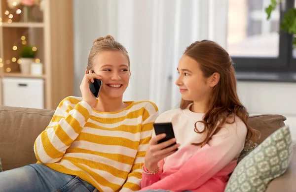 Meninas adolescentes felizes com smartphones em casa — Fotografia de Stock