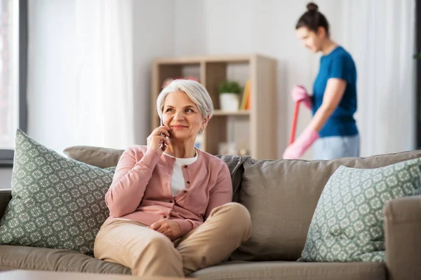 Happy senior woman calling on smartphone at home — Stok fotoğraf