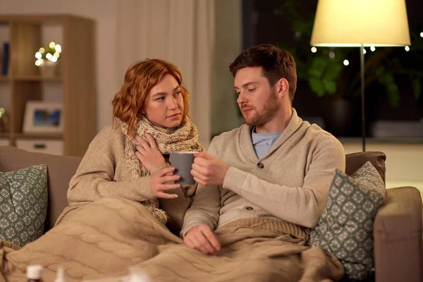 Enfermo joven pareja bebiendo té caliente en casa — Foto de Stock