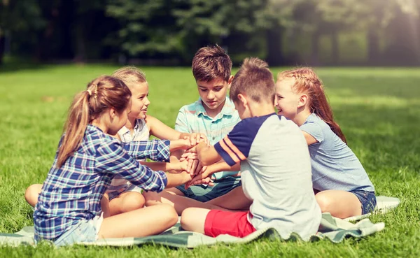 Group of happy kids putting hands together — Stock Photo, Image
