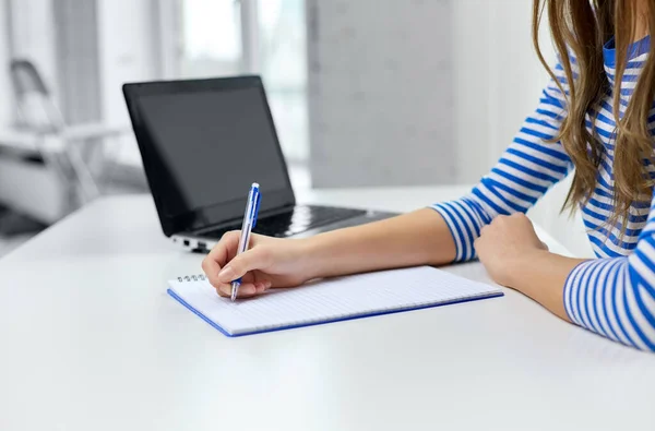 Menina estudante com caderno de exercícios, caneta e laptop — Fotografia de Stock