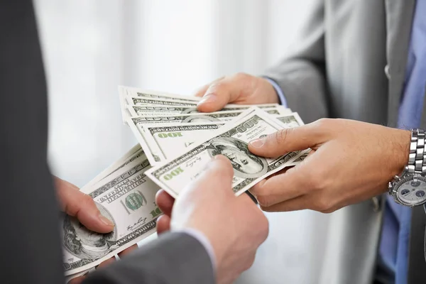 Primer plano de los hombres de negocios manos sosteniendo el dinero — Foto de Stock
