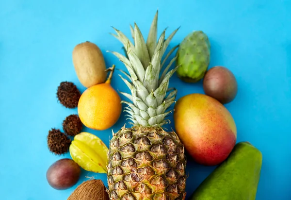 Muchas frutas exóticas diferentes sobre fondo azul — Foto de Stock