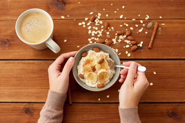 Händer med havregryn frukost och kopp kaffe — Stockfoto