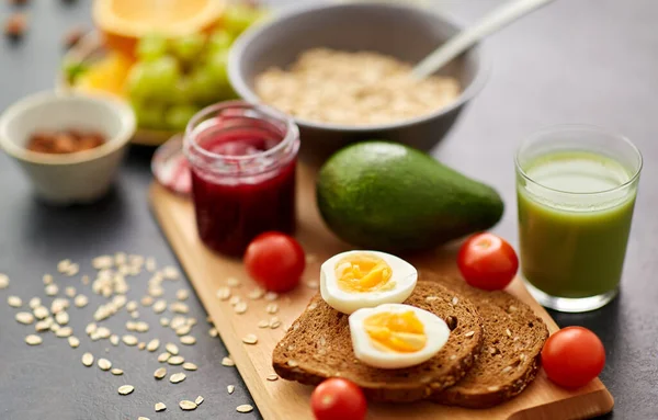 Roti panggang, telur, alpukat, selai, tomat dan jus — Stok Foto