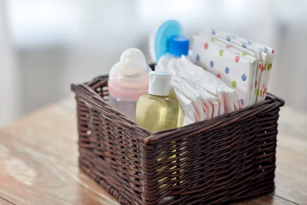 Baby things in basket on wooden table at home — Stock Photo, Image