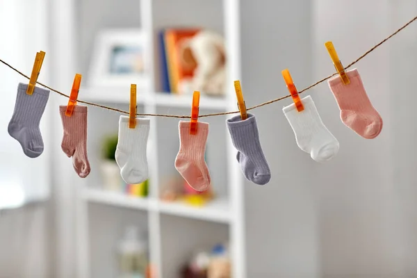 Calcetines pequeños para niña en el tendedero en casa — Foto de Stock