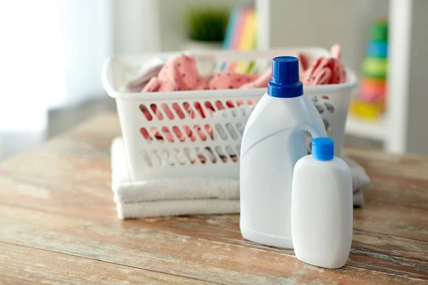 Baby clothes in laundry basket with detergent — Stock Photo, Image