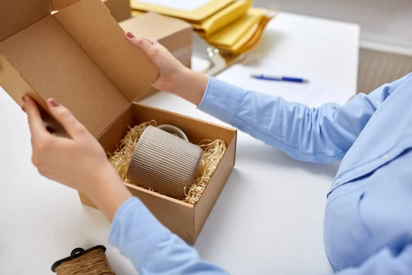 Frau packt Becher in Paketkasten bei Post — Stockfoto