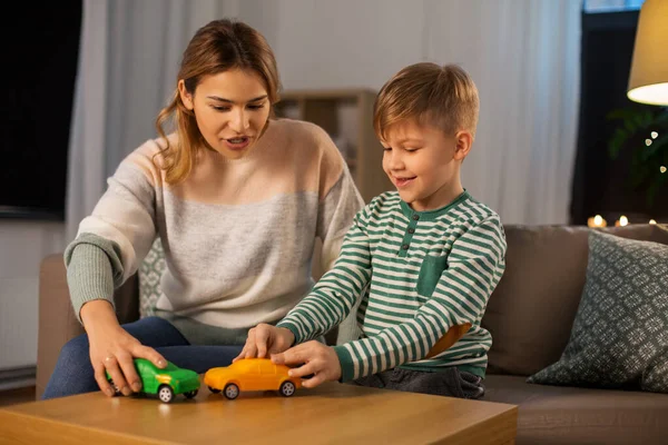 母親と息子はおもちゃの車で家で遊んでいます — ストック写真