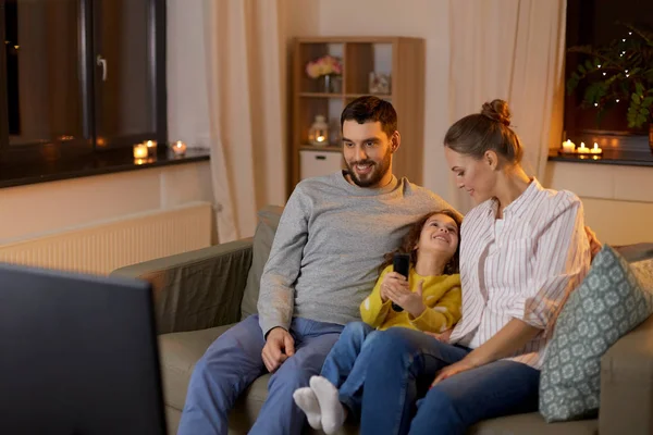 Familia feliz viendo la televisión en casa por la noche — Foto de Stock