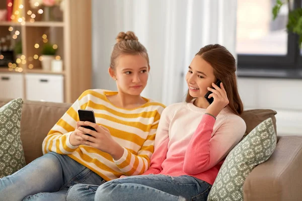 Happy teenage girls with smartphones at home — Stock Photo, Image